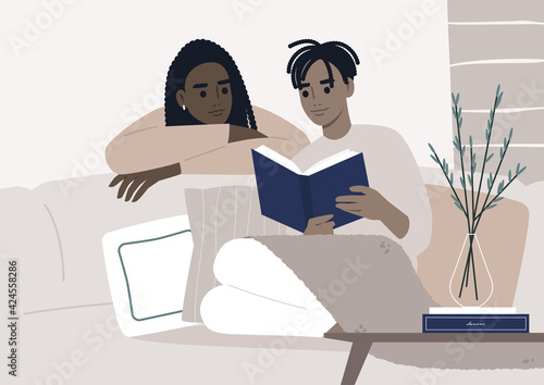 Weekend leisure activities, a couple reading a book together in the living room, cozy domestic life during the lockdown