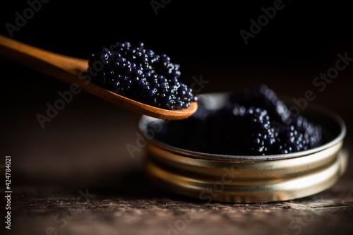 Black lumpfish caviar in a small pot and spoon