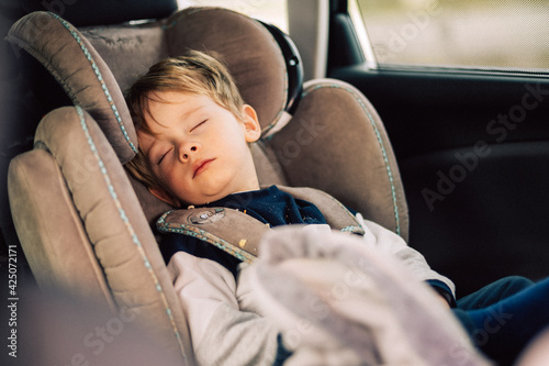 Enfant dort dans son siège auto.