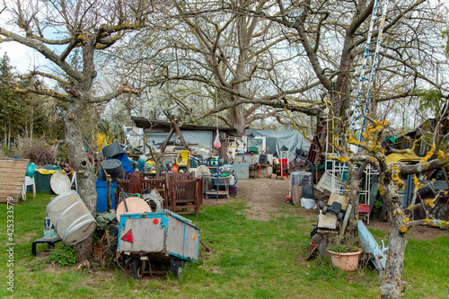 Hoarding disorder. Neglected allotment garden of people who suffers from compulsive hoarding, littered with trash and other items. Messy, Compulsive hoarding disorder concept - stuff in the garden