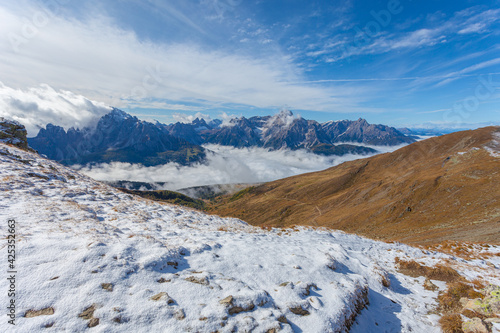 Panorama of Pustertal valley covered by clouds with amazing dolomite peaks background, South Tyrol, Italy. Atmosphere of tranquility, relaxation and meditation