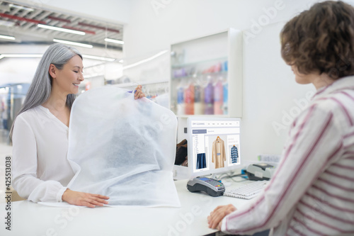 Two women in dry cleaning near counter