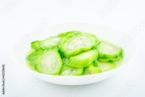 A dish of angular loofah on a white background