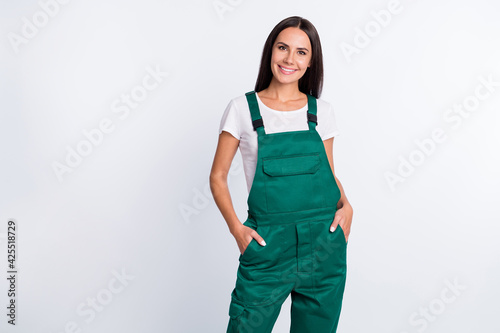 Photo of charming confident lady arms pockets shiny smile wear green overall isolated white color background