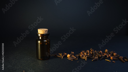 Aromatherapy at home for mind and body fulfilment. Essential oil vintage bottle surrounded by clove seeds. Perfumery background minimal design. 