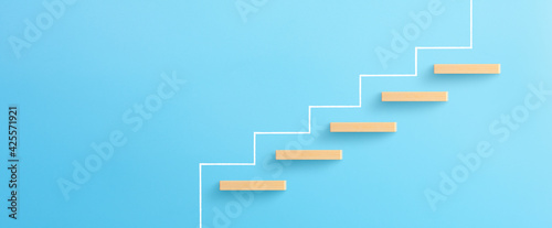 Ladder of success in business growth concept, Wooden block stacking as step stair on blue background, copy space