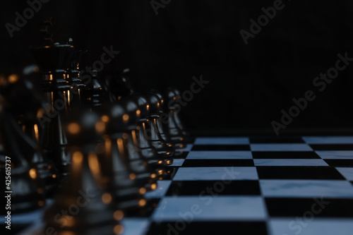 Chess standing confront of chess team to challenge concepts of leadership and business strategy management and leadership. White and black pieces on chess board.