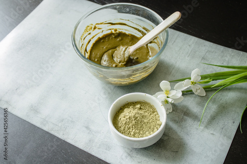 The glass bowl with rehydrated henna and dry henna powder on a marble mat. Home hair coloring by organic eco-friendly paint.