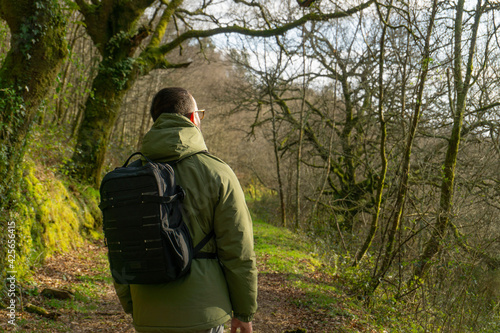 Happy man walking on a path with a backpack. Lifestyle concept, hike, outdoors.
