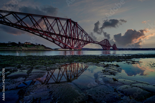 Sunset sky and reflection at the Forth Rail Bridge from North Queensferry, Fife, Scotland.