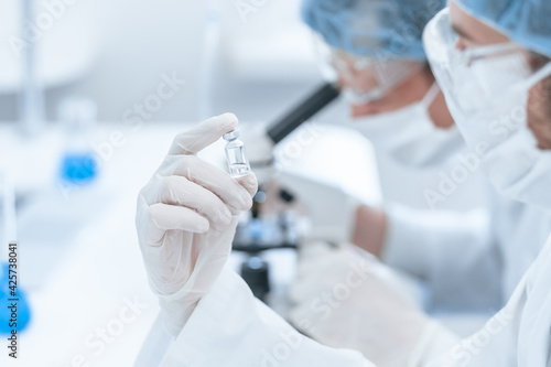 close up. ampoule with a new vaccine in the hands of a scientist.