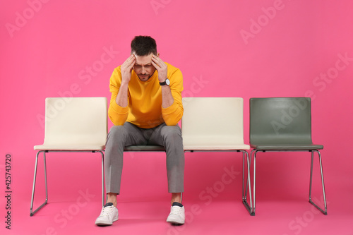 Man waiting for job interview on pink background