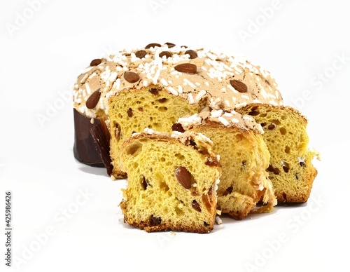 Colomba Pasquale, typical italian easter cake,with some slices in front. The name means Easter Dove in english language, due to its shape. White background.