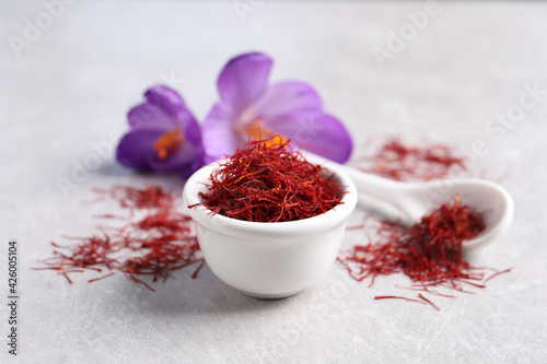 Dried saffron and crocus flowers on grey table, closeup