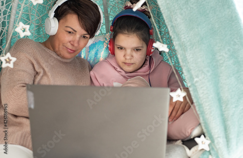 Dziecko z mamą podczas nauczania zdalnego, kwarantanna w domu, epidemia koronawirusa, praca zdalna z domu na laptopie, nauka zdalna na komputerze