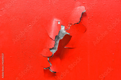 Red metal texture with parts of paint peeling off.