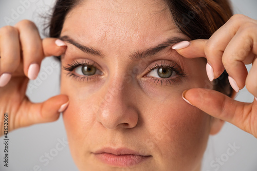 Close-up portrait of Caucasian middle-aged woman showing expression lines around eyes. Signs of aging on the face