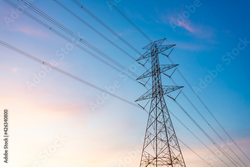 high-voltage power lines, high voltage electric transmission tower for producing electricity at high voltage electricity poles at the sunset.