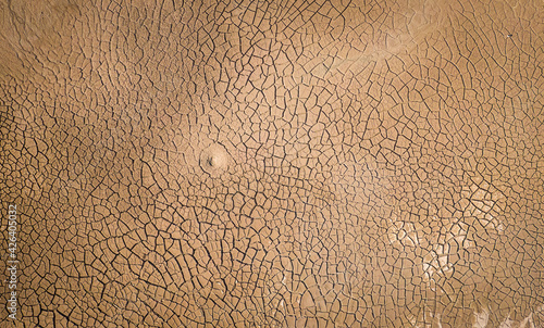 Dried lake bottom surface texture. Aerial shot of dried clay with cracks, flat view directly above