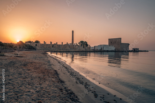 Dawn light on the ruins of the old factory for the processing of tuna and of the medieval watch tower at Vendicari, Syracuse, Sicily, Italy.
