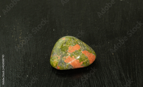 Unakite pebbles green epidote natural mineral stone from Republic of South Africa RSA. Mineralogy, geology, magic of stones, semi-precious stones and samples of minerals. Close-up macro photo.