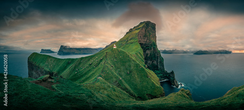 Panorama at Lighthouse with steep cliffs during sunset on Faroese island Kalsoy, Faroe Islands.