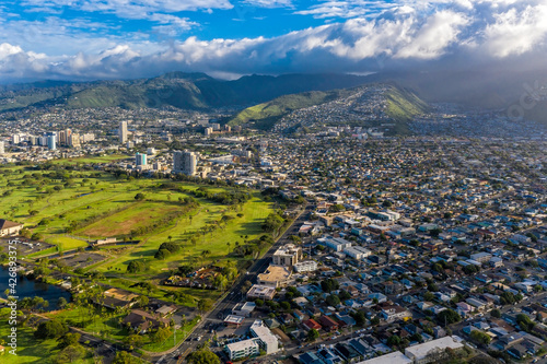 Aerial view on Honolulu suburbs located on green land and mountains, Oahu Island, Hawaii