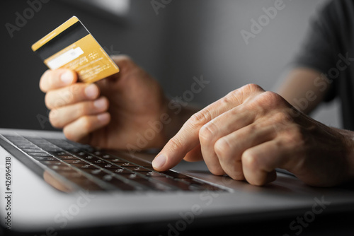 Online shopping. Man hand holding credit card and using laptop at office, Businessman or entrepreneur working , e-commerce, internet banking, spending money, working from home concept