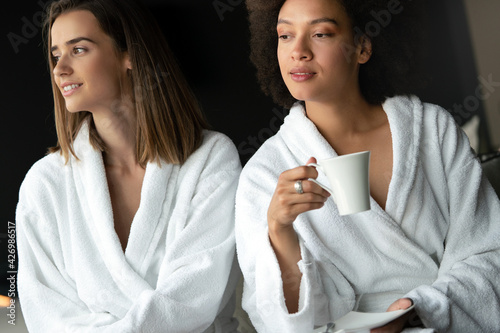 Attractive happy young women drinking coffee at spa center