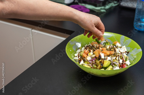Close up view of woman putting grapefruit in salad salad bowl. Healthy eating concept.