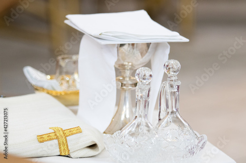 Liturgical objects, sacred vessels: glass altar cruet and liturgical bowl near the altar during the Holy Mass in the Catholic Church