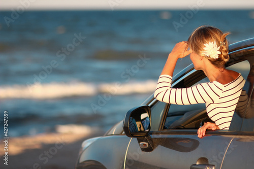 A Happy girl in the car by the sea in nature on vacation travel
