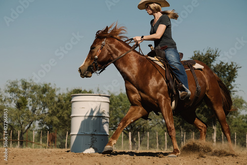 Barrel racing practice with cowgirl riding sorrel mare quarter horse, western rodeo lifestyle.