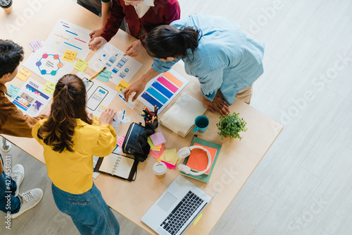 Multiracial group of young creative people in smart casual wear discussing business brainstorming meeting ideas mobile application software design project in modern office. Coworker teamwork concept.