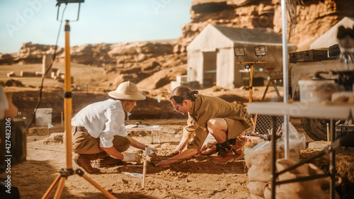 Archeological Digging Site: Two Great Archeologists Work on Excavation Site, Cleaning Cultural Artifacts with Brush and Tools. Discovery of Ancient Civilization Temple, Architecture, Fossil Remains