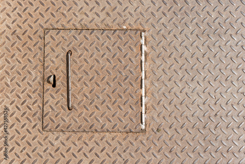close up of a trap door on an anti-slip textured metal plate