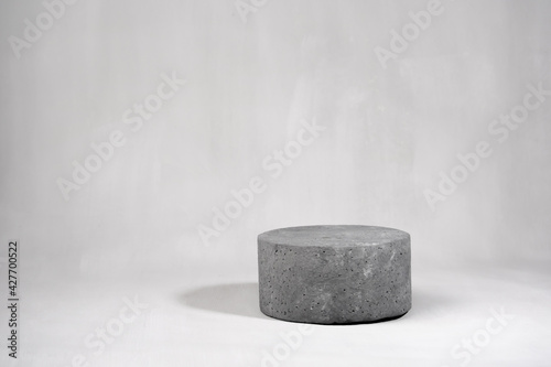 Empty round cylinder product stand on gray concrete background. Mock up. Copy space.