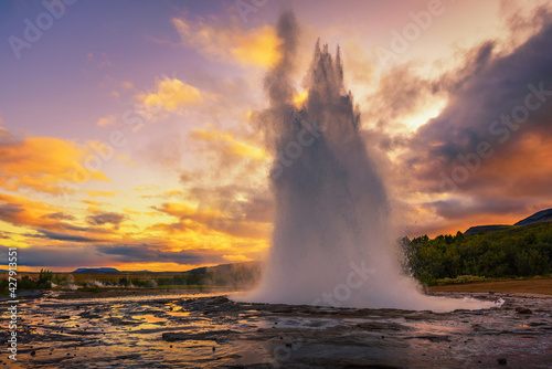 Eruption of Strokkur geyser in Iceland at sunset