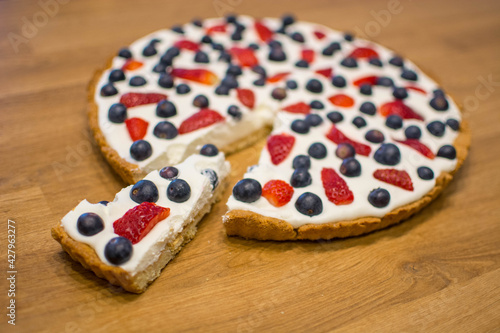 Tarta na kruchym cieście z bitą śmietaną i owocami - truskawkami i borówkami