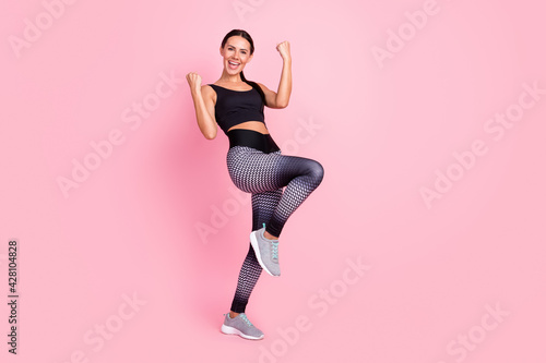 Full size photo of happy young charming lady raise hands champion sport isolated on pink color background
