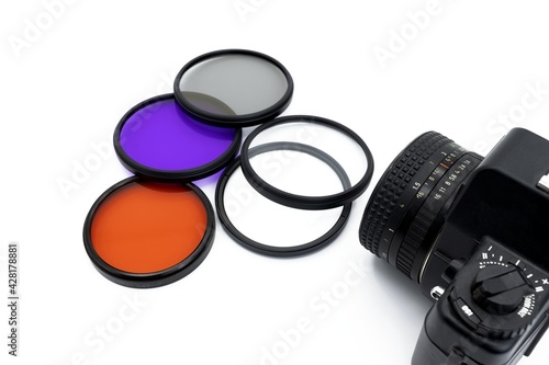 Photographic filters of various colors on a white background with a camera, photography concept