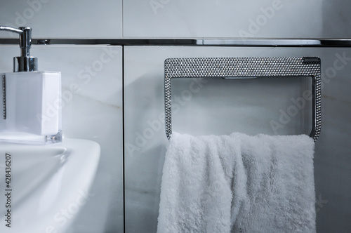 Detailaufnahme eines Badezimmers. Angefertigter strassbesetzter Handtuchhalter, Handtuchring mit weißem Handtuch