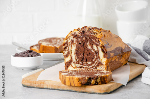 Loaf of marble pound cake on a board on a gray concrete background. Copy space.