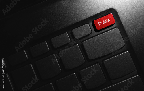 Red delete key button. Keyboard laptop in the dark. Abstract business concept background.