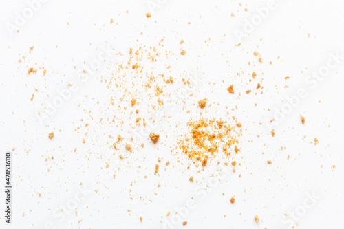 scattered crumbs of roasted white bread on a white background closeup