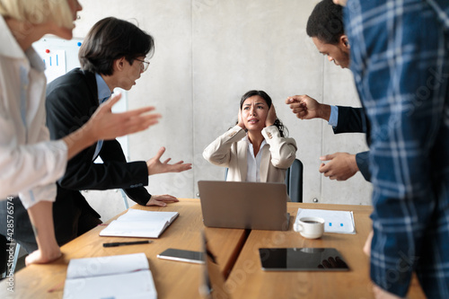 Aggressive Coworkers Shouting Criticizing Unhappy Victimized Female Worker In Office