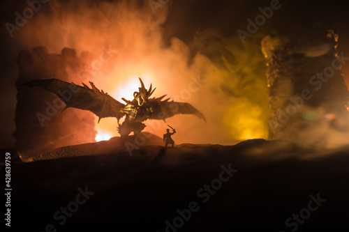 Battle between dragon and heroic soldiers. Creative table decoration. Selective focus