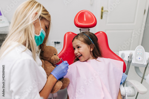 Śliczny małej dziewczynki obsiadanie na stomatologicznym krześle i mieć stomatologicznego traktowanie.