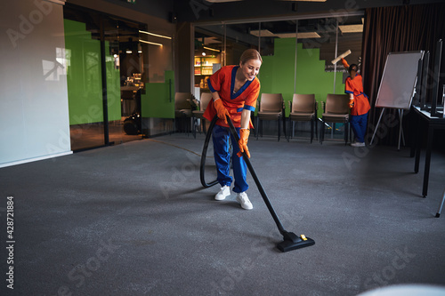 Janitorial staff using a microfiber scrubber and a vacuum cleaner