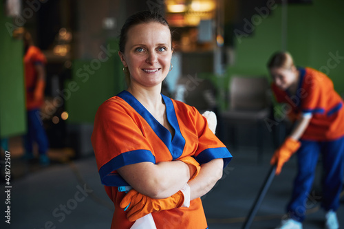 Pleased janitor posing for the camera during the office cleaning